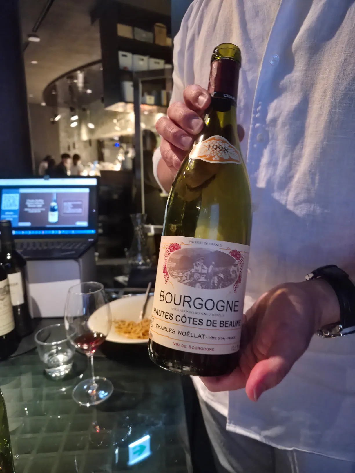 Charles Noëllat Hautes-Côtes de Beaune 1998 병을 든 장면
